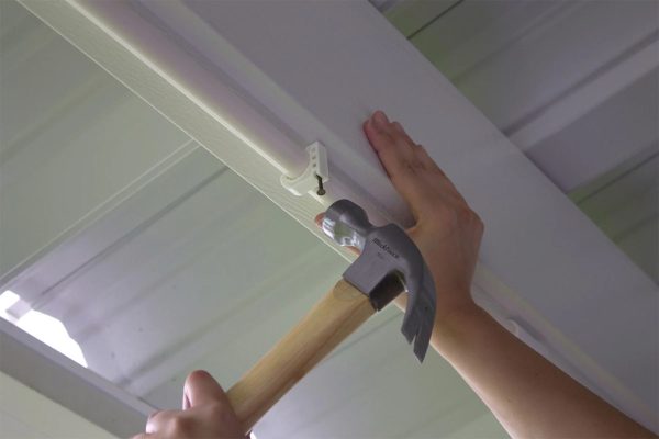 Orbit 20070 PVC Preassembled Mist Cooling Kit is being installed on the ceiling using nail clips